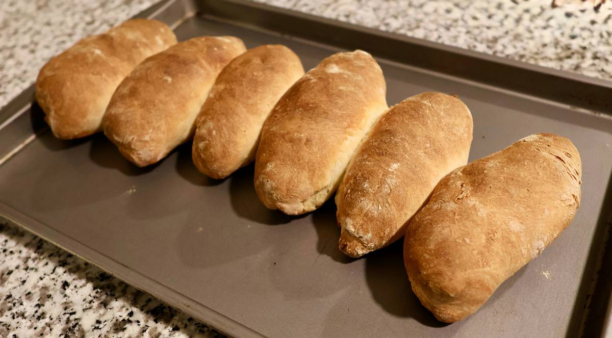 how to make italian panini - close-up of golden-brown ciabatta sandwich pressed evenly on cast-iron panini press plates